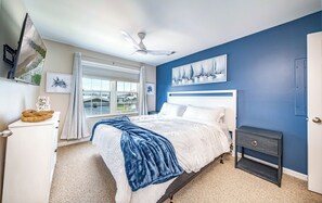 Coastal king bedroom with bold accent wall and smart TV
