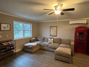 Living room with Lovesac sofa with convertible queen bed and wine rack. 