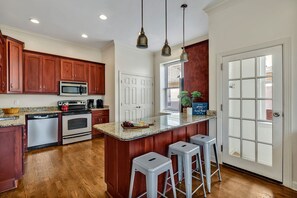 2nd Floor: Fully equipped kitchen stocked with your basic cooking essentials, including stainless steel appliances and a kitchen island.