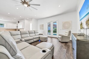 Open Floor Plan on the 1st Floor Starts With This Oversized Couch with Charging Stations, Large Smart Tv and Direct Access to the Outside Pool Deck