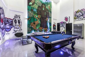 Atmospheric and artistic game room with a pool table and foosball.