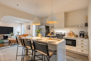 Kitchen features an island with barstool seating.