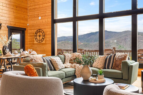 Step into sophistication where rustic charm meets modern elegance! 🛋️✨ This beautifully designed living room features a plush sofa set and an elegant coffee table, all framed by breathtaking mountain views through expansive windows. It’s the perfect serene retreat to unwind and soak in nature's beauty.