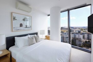The primary bedroom boasts the comfort of air-conditioning and floor-to-ceiling glass windows with breathtaking cityscape vistas. 
