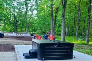 Relax in the hot tub in the peaceful wooded setting