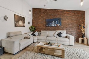 Get comfortable in the living area. There’s a large sofa fronting the TV and air-conditioning to keep things cool.
