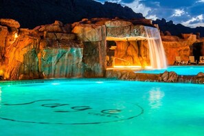 Gorgeous pool and waterfall lit up at night