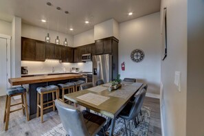 Open concept full kitchen with bar and dining table seat 10