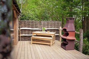 Spacious decking with Charcoal BBQ or a fire pit and outdoor furniture;