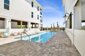 Poolside Perfection: Chic loungers await under the warm sun, nestled between coastal charm and cool waters.