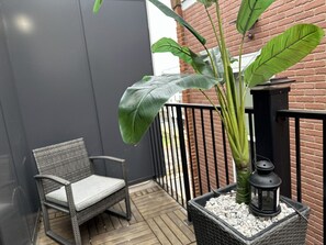 A serene private balcony adjacent to the bedroom, adorned with elegant outdoor furniture, offering a tranquil retreat.