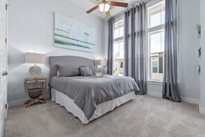 A peaceful retreat with plush bedding, tall windows, and soothing décor for a restful night's sleep.