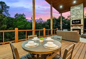 Watch the sun dip below the trees while gathered on the spacious back deck, complete with plenty of cozy seating.