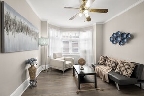 Living room features flat screen TV, sofa sleeper, cozy chair, and serene ambiance.