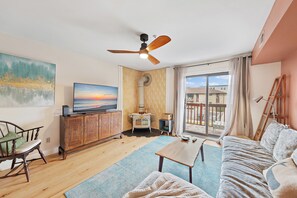 Comfortable and stylish living room with large TV and deck with water views