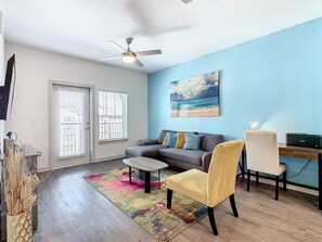 Blend of coziness and technology in our living room, with a sleek 50-inch TV.