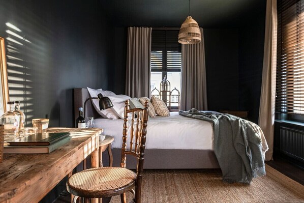 Luxury bedroom with renovated interior in Gatsby style.Kingsize bed with desk and armchair.