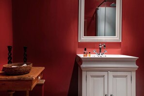 Renovated bathroom with private sink, shower and toilet including utilities such as towels and shampoo.