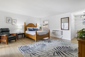 Unwind in this beautifully furnished bedroom featuring a comfortable bed, cozy seating area, and plenty of natural light.