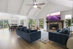 Relax in this spacious living room with vaulted ceilings, plenty of natural light, and a warm fireplace.