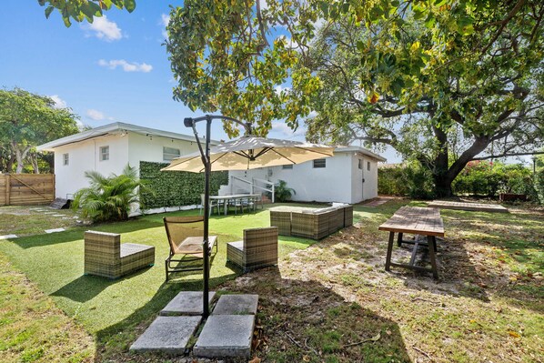 Enjoy the miami sunshine in this expansive backyard with a grill, TV & cocktails