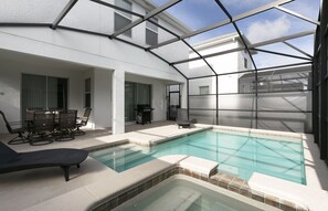 Outdoor area featuring a rejuvenating spa and a covered swimming pool.