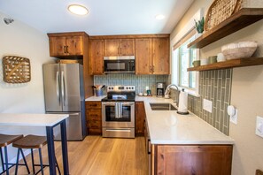 Kitchen with fridge, dishwasher, drip coffee maker, and beakfast bar.jpg
