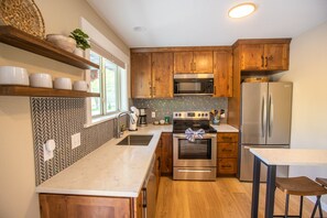 Kitchen with fridge, dishwasher, drip coffee maker, and breakfast bar.jpg