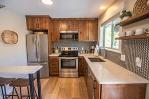 Kitchn with fridge, dishasher, drip coffee maker, breakfast bar.jpg