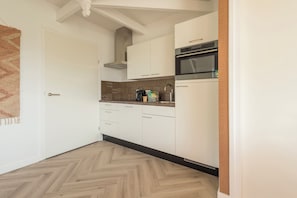 A fully equipped kitchen featuring sleek cabinetry, a built-in microwave, and a contemporary backsplash, perfect for convenient cooking.