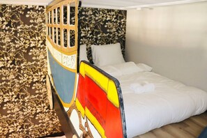 A playful and imaginative bedroom design featuring a vibrant boat-inspired bed, adding a fun element to the space.