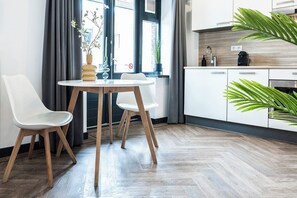 Enjoy a spacious living area with a comfortable sofa, chic pillows, and a sleek kitchen, where plants bring nature inside, offering a cozy retreat after visiting Efteling or Safari Park Beekse Bergen.