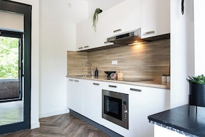 Onze gedeelde keuken bij Bed en Koffie Central, bereikbaar via de gemeenschappelijke gangen, is de ideale plek om samen maaltijden te bereiden en blijvende herinneringen te maken tijdens je verblijf in Tilburg.