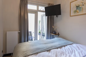 A cozy room with a soft bed, wall-mounted TV, and natural light streaming through glass doors, complemented by minimal decor and a small balcony view.
Goedkope overnachting in het hart van de stad, perfect voor shows bij Poppodium 013 en plezier met het gezin in de Efteling.