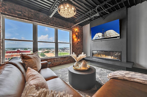 Immerse yourself in style with this living room, where stunning hardwood accents beautifully complement plush gray furniture and a chic camel leather sofa, creating a warm and inviting atmosphere.