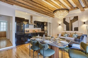 Superbe séjour avec grande table pour dîner et canapé lit et cuisine américaine équipée