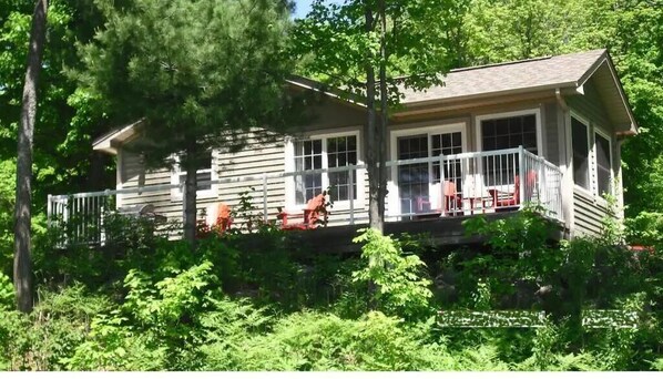 Back of cottage which overlooks the lake. 4 Adirondack chairs, gas grill.