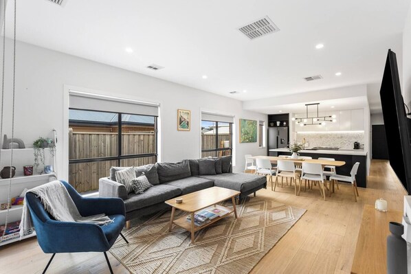 The living and dining area is open plan, framed by oversized windows that allow beautiful natural light to stream through.
