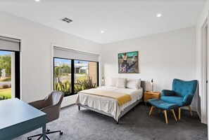 The primary bedroom comes with a queen-sized bed, along with a dedicated workspace for those on a business trip.
