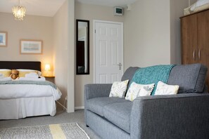 lounge bedroom, long wall mirror, 2 seater sofa with throw and cushions
