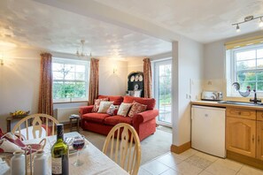 Open plan living room with sofa, patio doors and kitchen / dining area
