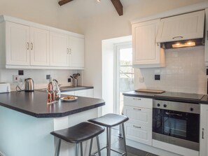 Kitchen area with breakfast bar and stools, cooker, sink