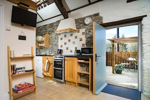 Fitted kitchen area, open doorway leading to patio.