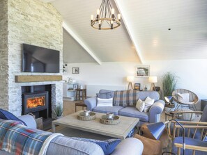 Lounge room with wood flooring, coffee table and fireplace.