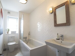 Bathroom with bath tub, shower, toilet and sink.