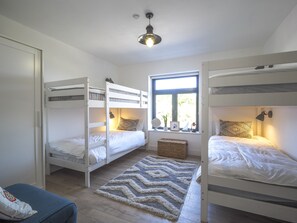 Twin bedroom with 2 bunk beds and a chair.