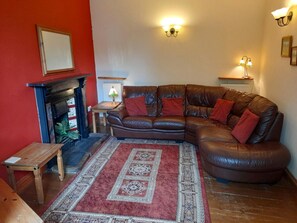Lounge with open fire, leather sofa and armchair