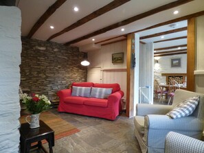 Living room with sofa, armchairs, entrance to dining area