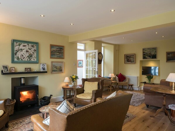 Lounge with wood burner, sofas and armchairs, tv