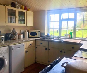 Kitchen with range cooker, sink, window, microwave